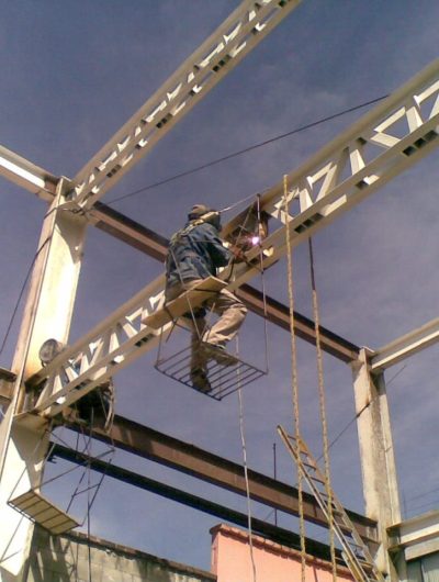Trabajador soldando estructura metálica en alturas MMS Arquitectos