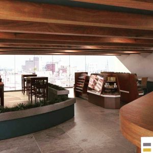 Diseño interior de cafetería con madera y ventanales MMS Arquitectos