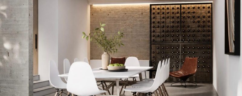 Comedor moderno de doble altura con mesa blanca, sillas, muro de ladrillo, cava de vinos iluminada y concreto aparente. Diseño por MMS Arquitectos en Estado de México y Ciudad de México