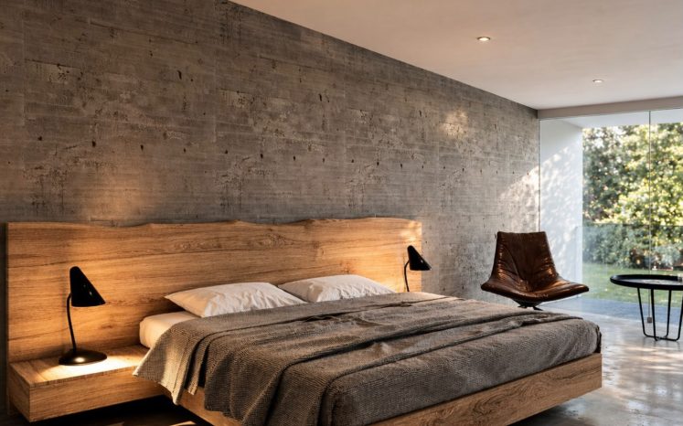 Recámara minimalista con muro de concreto, cama baja de madera, cabecera flotante y ventanal al jardín. Diseño interior por MMS Arquitectos en Estado de México y Ciudad de México
