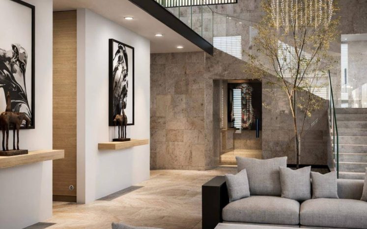 Sala minimalista a doble altura con escalera, árbol interior, lámpara colgante y sofás grises. Diseño interior por MMS Arquitectos en Estado de México y Ciudad de México